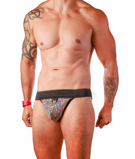 A man wearing a low-rise, thong-style brief with a wide black waistband and a colorful, iridescent patterned front panel, shown against a plain white background.