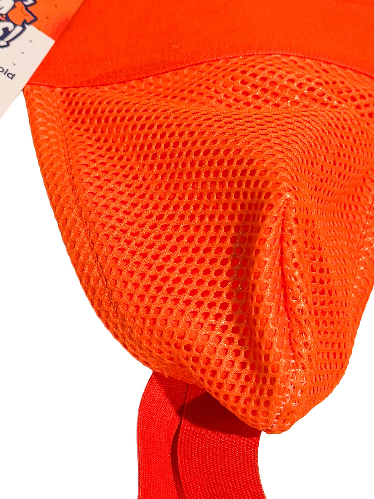 Bright orange mesh male chastity device with red elastic straps and a white product tag, shown on a plain white background.