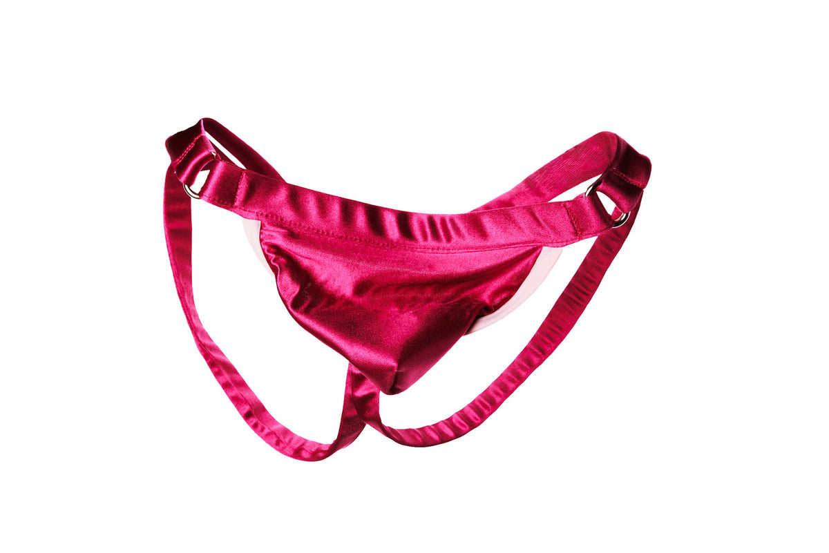 A hot pink satin thong with adjustable straps and a small metal ring at the back, displayed against a solid white background.